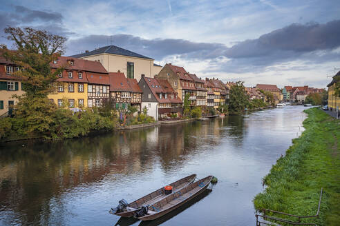 Deutschland, Bayern, Bamberg, Boote auf dem Fluss mit Stadthäusern im Hintergrund - ISF24747