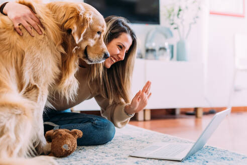 Italien, Junge Frau mit Hund schaut auf Laptop - ISF24829