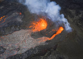 Von oben sprudelt Magma aus dem Vulkanloch und fließt wie Lavaströme über den Boden in Island - ADSF25606