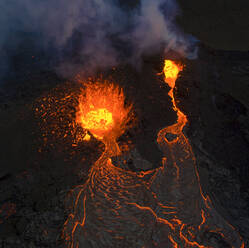 Von oben sprudelt Magma aus dem Vulkanloch und fließt wie Lavaströme über den Boden in Island - ADSF25611