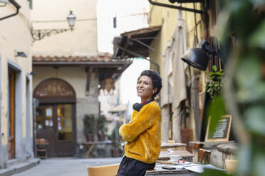 Italy, Tuscany, Pistoia, Smiling woman leaning against table in outdoor cafe - ISF24840