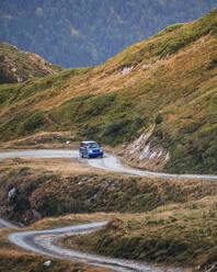 Modernes Auto auf staubigem Weg in den grünen Bergen der Pyrenäen mit Wald in Spanien - ADSF25635