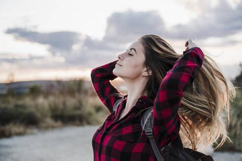 Beautiful young woman with eyes closed hands in hair - EBBF04227