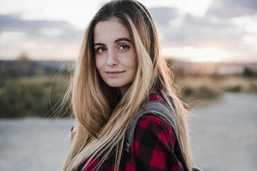 Young woman blond hair wearing plaid shirt during sunset - EBBF04228