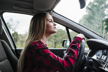 Beautiful young woman driving in car - EBBF04265