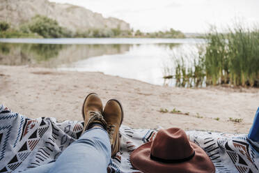 Young woman relaxing by lake while camping - EBBF04270