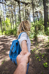 Reifer Mann, der seiner Freundin folgt, während er im Wald die Hände hält - SIPF02308