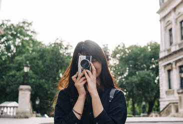 Young female photographer shooting with old-fashioned camera - ASGF00785