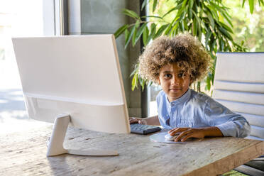 Afro boy sitting in front of computer at home - DLTSF02005