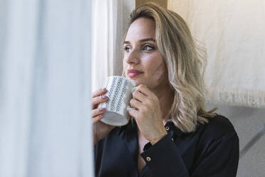Businesswoman having coffee at home - PNAF02035