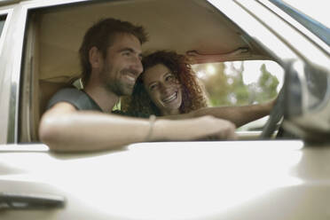 Happy young couple in car traveling during road trip - AJOF01529