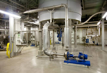 Interior of brewery, large steel storage tanks for brewing beer with metal pipes and valves. - MINF16302