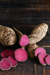 Overhead composition of organic natural beetroot cut into slices and arranged on shabby wooden surface - ADSF25736