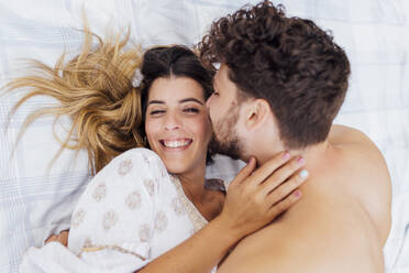 Glückliche Frau liegt mit ihrem Freund ohne Hemd auf einer Picknick-Decke - EGHF00094