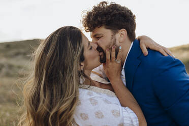 Affectionate couple kissing each other on mouth at sunset - EGHF00113