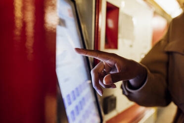 Frau benutzt Fahrkartenautomat in einer U-Bahn-Station - MEUF03529