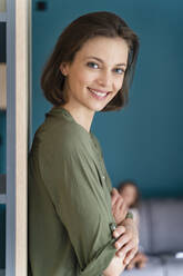 Smiling woman with arms crossed at home - DIGF16111