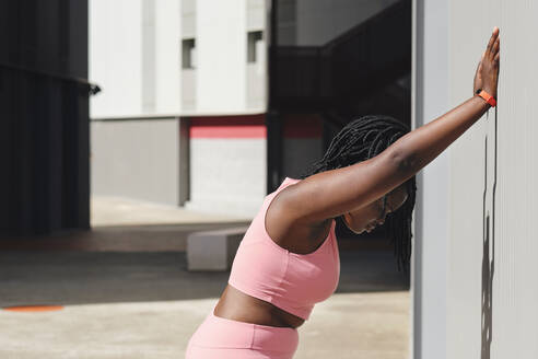 Tired curvy young woman leaning on corrugated wall - AODF00555