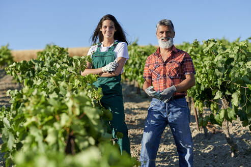 Lächelnde Landwirte und Landwirtinnen in einem Weinberg - KIJF04021