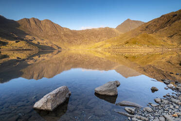 Early morning sunlight on Snowdon in spring, reflected in Llyn Llydaw, Snowdonia National Park, Wales, United Kingdom, Europe - RHPLF19986