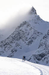 Touristen beim Fotografieren der verschneiten Gipfel während einer Winterwanderung, Muottas Muragl, Samedan, Engadin, Kanton Graubünden, Schweiz, Europa - RHPLF20110