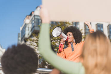 Afroamerikanische Kämpferin für soziale Gerechtigkeit mit Rednerin gegen Ernte anonyme, multirassische Menschen mit Plakaten, die in der Stadt für Menschenrechte kämpfen - ADSF26083