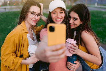 Fröhliche beste Freundinnen nehmen Selbstporträt auf Handy, während sie Zeit zusammen in der Stadt verbringen - ADSF26230