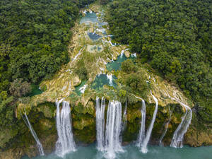 Luftaufnahme eines Wasserfalls von einer Felsformation inmitten von grünen Bäumen, Huasteca Potosi, Mexiko - RUNF04607