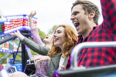 Friends screaming while enjoying amusement park ride - WPEF05059