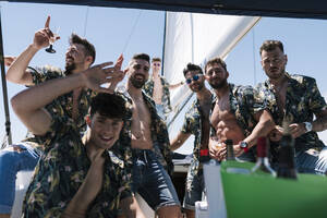 Men gesturing while enjoying party on yacht during summer - EGAF02447