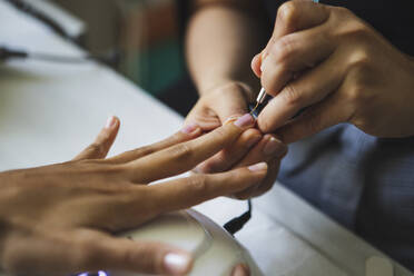 Von oben der Ernte unerkennbar Maniküre tun Nagelkunst fpr weiblichen Kunden in Schönheitssalon im Tageslicht - ADSF26523