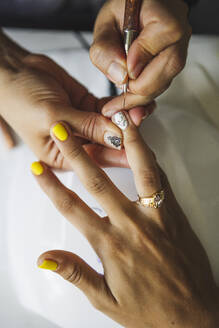Von oben der Ernte unerkennbar Maniküre tun Nagelkunst für weibliche Kunden in Schönheitssalon im Tageslicht - ADSF26527