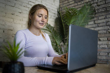 Female freelancer working on laptop at home - RCPF01180