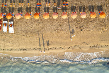 Luftaufnahme von Sonnenschirmen in einer Reihe am Sandstrand, umspült vom kristallklaren Meer, Vieste, Provinz Foggia, Gargano, Apulien, Italien, Europa - RHPLF20320