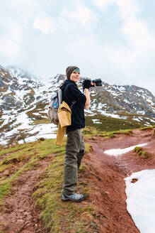 Seitenansicht Ganzkörper weiblichen Touristen mit Rucksack mit Fotokamera während der Aufnahme erstaunliche Natur der Peaks of Europe während der Reise - ADSF26773