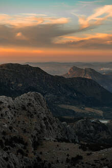 Blick auf ein weitläufiges Berggebiet mit grünen Hängen bei Sonnenuntergang in Sevilla, Spanien - ADSF26784