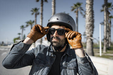 Hübscher Mann mit Helm und Sonnenbrille an einem sonnigen Tag - RCPF01192