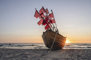 Einsames Fischerboot am Sandstrand bei Sonnenuntergang - KEBF02015