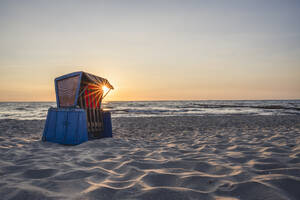 Strandkorb mit Kapuze am sandigen Küstenstrand bei Sonnenuntergang - KEBF02017