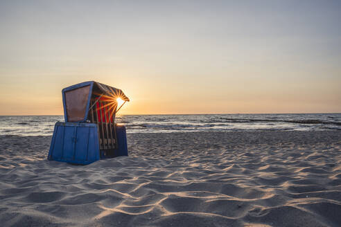 Strandkorb mit Kapuze am sandigen Küstenstrand bei Sonnenuntergang - KEBF02017