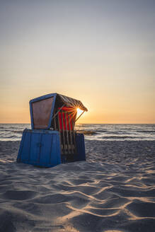 Strandkorb mit Kapuze am sandigen Küstenstrand bei Sonnenuntergang - KEBF02018