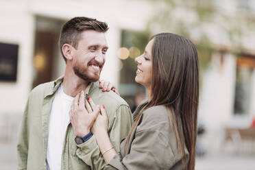 Mid adult man smiling while looking at girlfriend - LJF02250