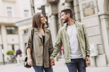 Lächelnd Mitte erwachsenen Paar Blick auf einander beim Gehen auf der Straße Stadt - LJF02256