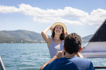 Mann mit glücklicher junger Freundin auf einem Ausflugsboot an einem sonnigen Tag - EIF01658