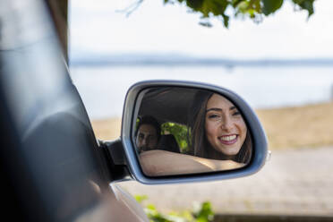 Reflection of smiling couple on side-view mirror - EIF01705