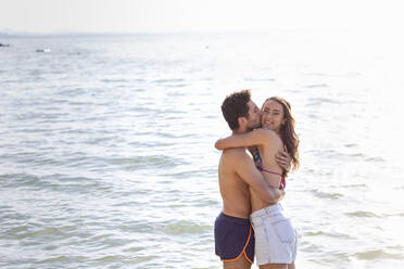 Boyfriend kissing while hugging girlfriend by Lake Trasimeno - EIF01718