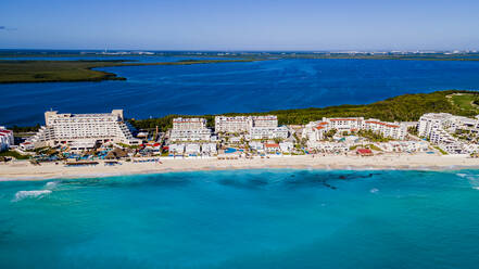 Mexico, Quintana Roo, Cancun, Aerial view of coastal city surrounded by blue waters of Caribbean Sea - RUNF04629