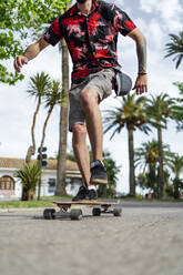 Mann balanciert beim Skateboardfahren auf der Straße - PGF00669