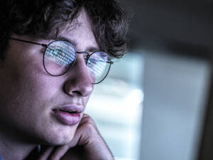 Besorgter Jugendlicher mit Spiegelung auf der Brille - ABRF00904
