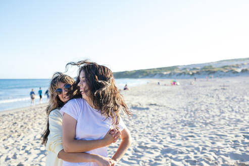 Fröhliches lesbisches Paar vergnügt sich am Strand - JCMF02110